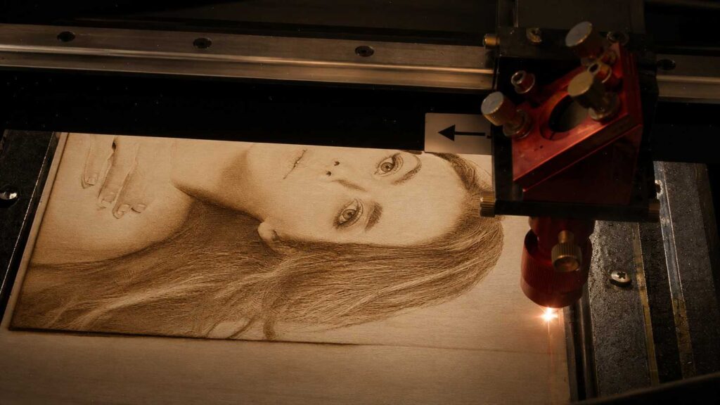 Is a 40W Diode Laser Too Powerful for Detailed Engraving? 3 A laser engraver producing a detailed, realistic portrait of a woman on a wood panel