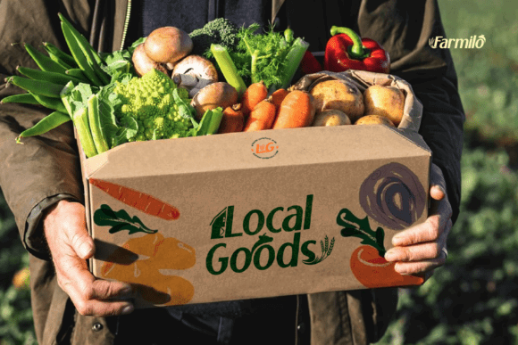 70+ Food Logo Fonts for Restaurants, Cafes, and Food Brands 92 A person holding a box of fresh vegetables and fruits labeled 'Local Goods'.