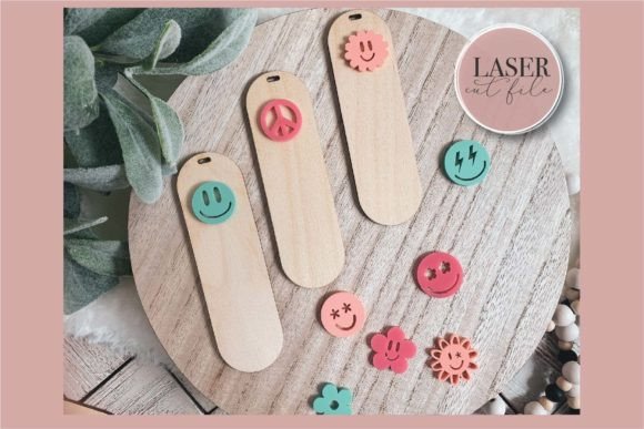 99+ Laser Cut Wood Projects To Sell From Home 92 Laser cut wood bookmarks with colorful smiley faces and shapes on a wooden round display.