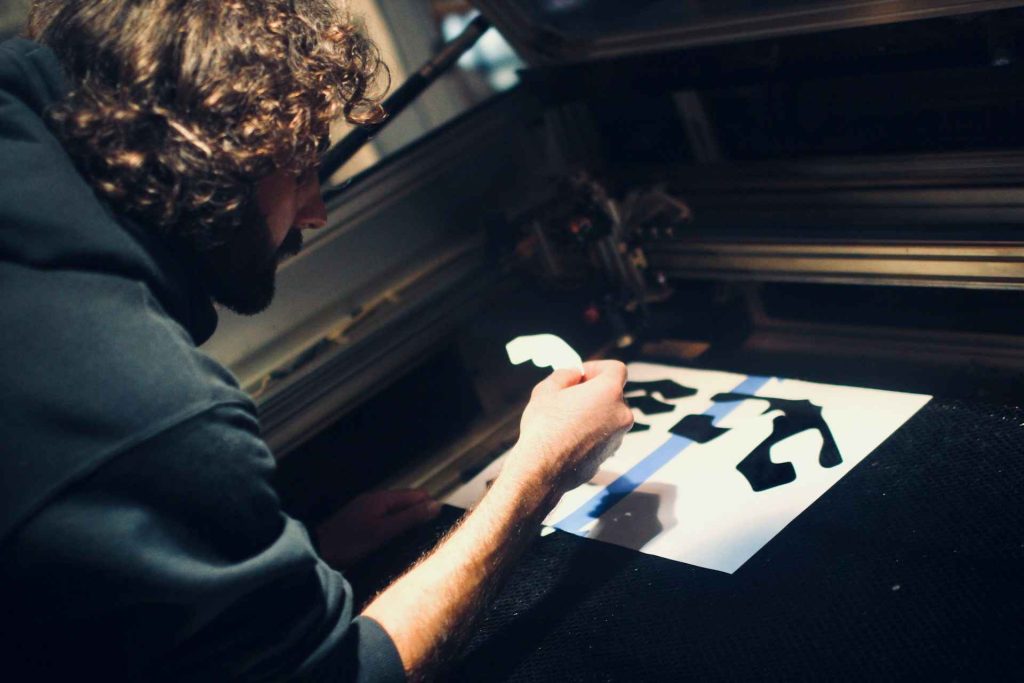 Beginner Laser Cutting Mistakes: 9 Costly Lessons I Learned 2 A person inspecting a small cut-out piece from a laser cutting machine. Beginner Laser Cutting Mistakes That Waste Money