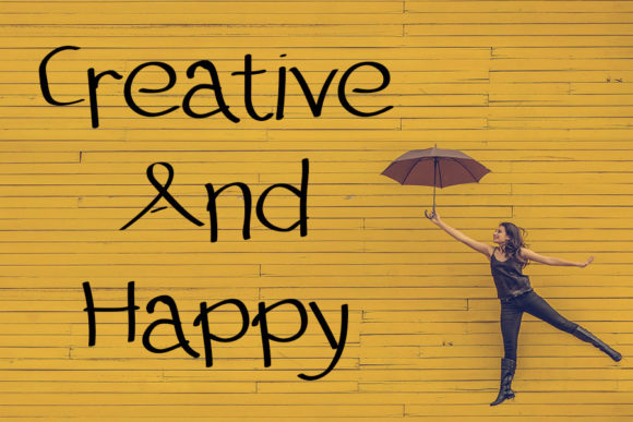 Halloween Fonts: 44 Best Picks for Cards, Signs & Cricut 36 A woman holding an umbrella against a yellow wall with the text 'Creative And Happy'.