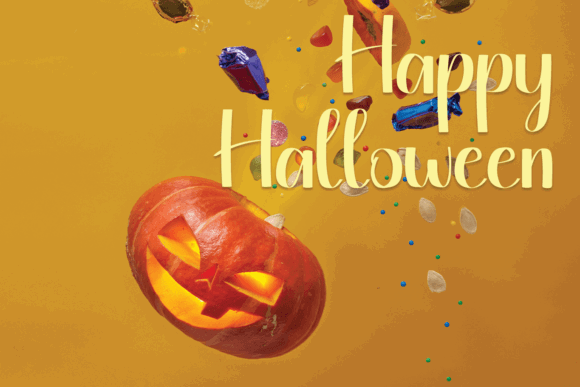 Halloween Fonts: 44 Best Picks for Cards, Signs & Cricut 41 Carved pumpkin with a spooky face and colorful candies on a yellow background.