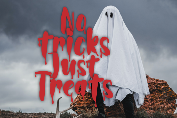 Unusual Halloween Fonts: 35 Creative Picks for Standout Designs 15 Person dressed as a ghost with white sheet and black eyes standing on rocky ground under cloudy sky with red dripping text